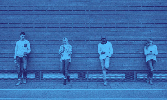 Four people leaning against a wall side by side.