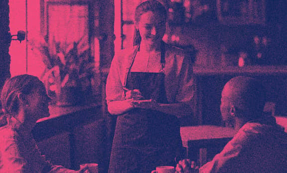 A student waitress taking orders at a restaurant.