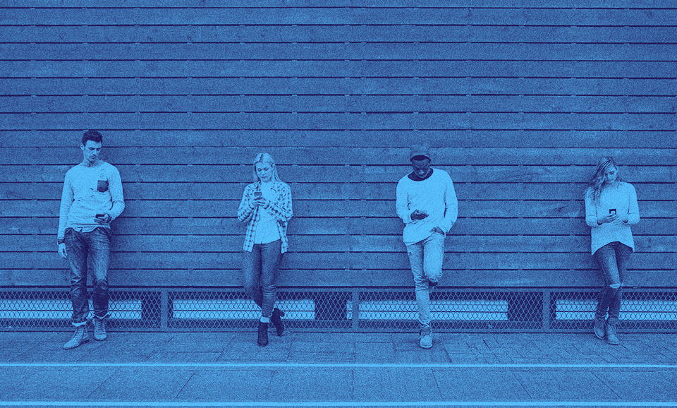 Four people leaning against a wall side by side.