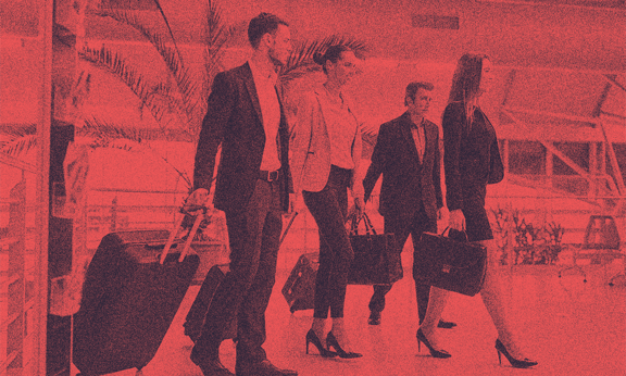 Business people in an airport, pulling their luggage.