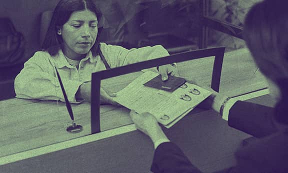 A woman is taking her files from an immigration office counter.